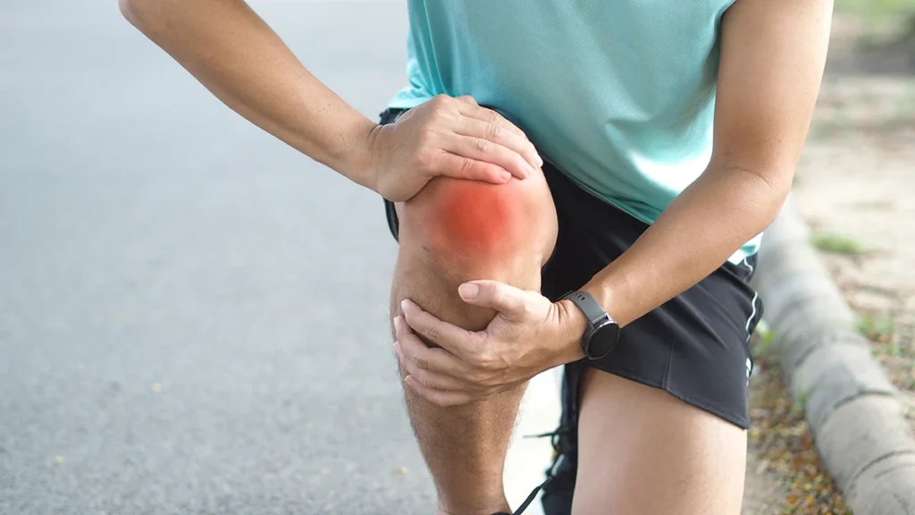 Runner che si tocca il ginocchio e dimostra di avere un forte dolore