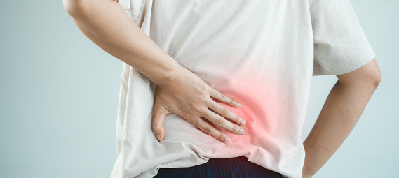 Persona con dolore nella zona lombare che indica la schiena con la mano, area evidenziata da un alone rosso simbolo di infiammazione