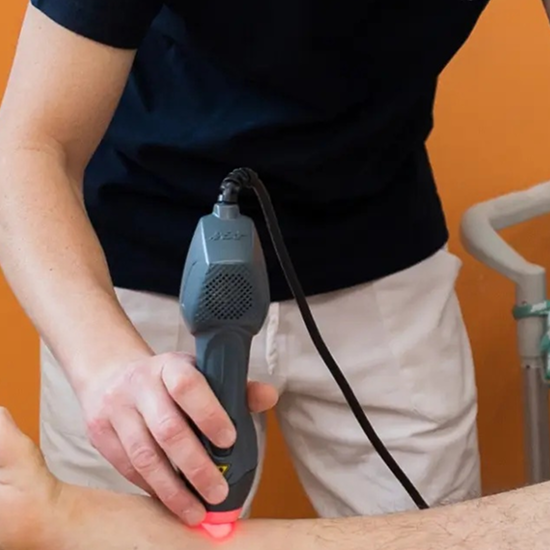 Operatore sanitario applica un dispositivo laser ad alta potenza sul ginocchio di un paziente per trattare dolore e infiammazione
