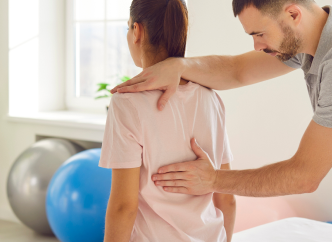 Fisioterapista che tratta una donna con dolore alla schiena e cervicale