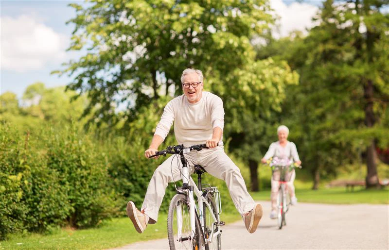 Anziani in bicicletta durante una bella giornata di sole