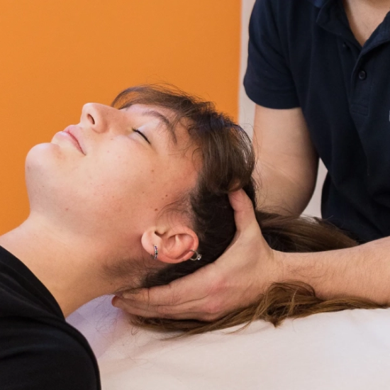 Fisioterapista effettua manovra cervicale su paziente durante la fase di terapia per dolori muscolo-scheletrici