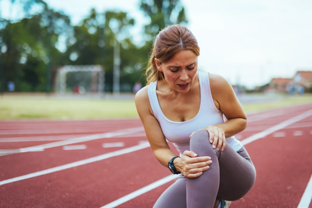 Atleta che si tiene il ginocchio fra le mani a causa di un possibile infortunio