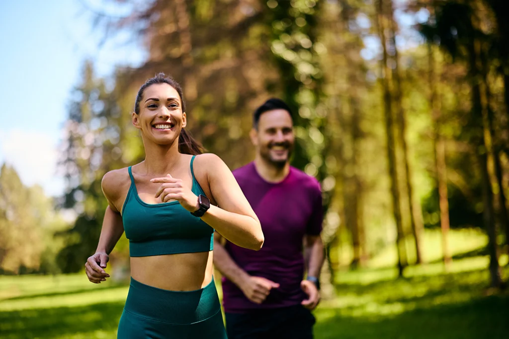 uomo e donna che praticano jogging all'aria aperta in un parco