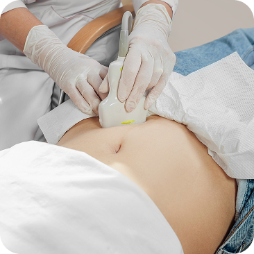 Operatore esegue ecografia addominale con sonda su paziente donna