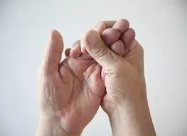 Esercizio di riabilitazione della mano eseguito con l'aiuto dell'altra mano, utile nel recupero motorio dopo danni neurologici come ictus o neuropatie