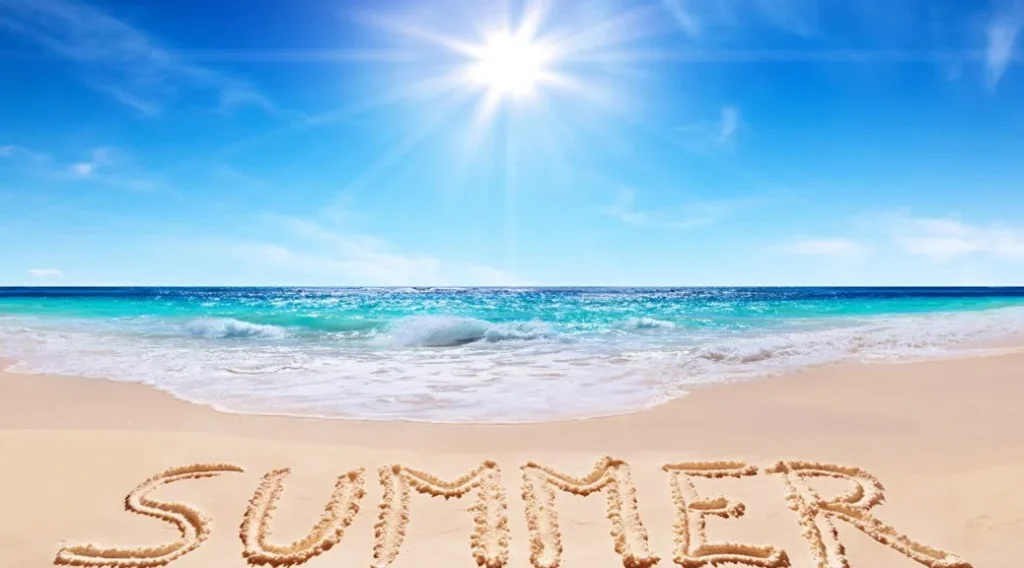 Spiaggia con cielo sereno, mare calmo e la parola “Summer” scritta sulla sabbia